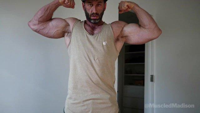 Madison flexes his biceps and chest and shows off his muscled physique